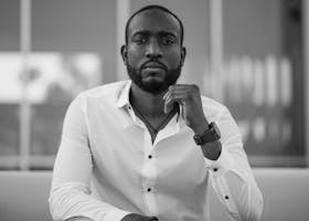 Black and white portrait of a stylish man in a white shirt indoors.